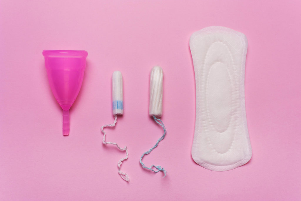 Pad, menstrual cup, tampon on a pink background.